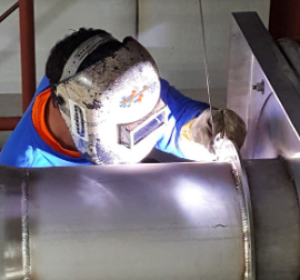 Image shows commercial HVAC fabrication and welding by a technician at Nordic Temperature Control, Burlington, WA.